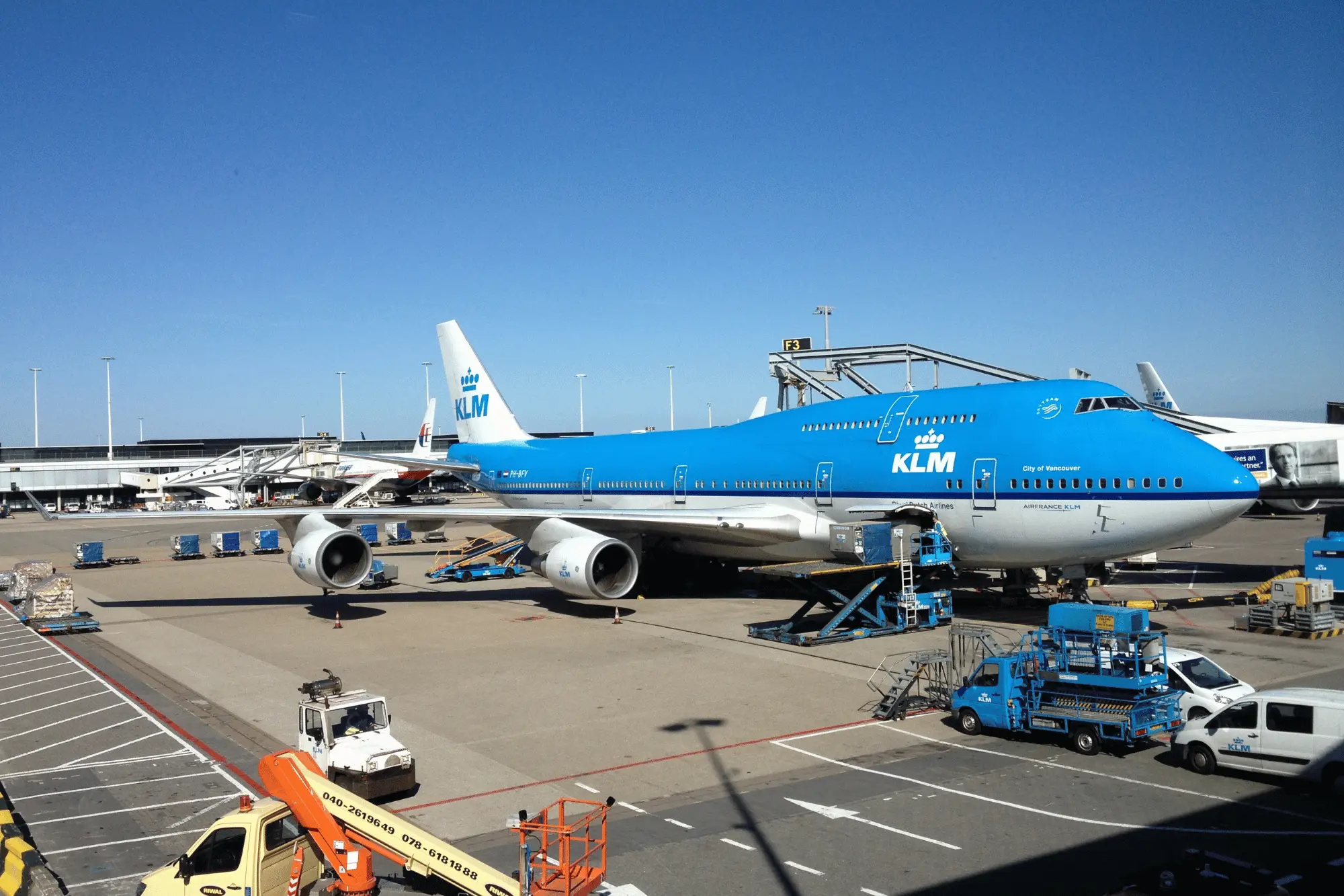 Professional chauffeur waiting at Schiphol arrivals hall with a name board